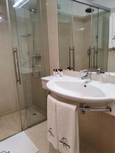 a bathroom with a sink and a shower at Hotel Dunas d'Ovar in Ovar