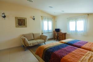 a bedroom with two beds and a couch and a chair at Hotel Rural La Consulta De Isar in Isar