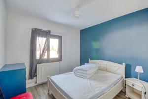 Schlafzimmer mit einem Bett mit blauen Wänden und einem Fenster in der Unterkunft Gentiane in Saint-Amandin