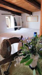 ein Schlafzimmer mit einem Bett und einem Tisch mit Blumen in der Unterkunft Case di Berto in Capo Vaticano