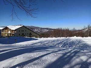 a snow covered road with a house in the background at Residence le Polle in Riolunato