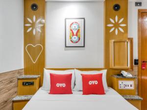 Habitación de hotel con cama con almohadas rojas en OYO Estrela Dalva, São Paulo, en São Paulo