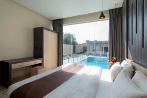 - une chambre avec un grand lit et une piscine dans l'établissement The Corner Hotel Resorts - Riyadh, à Riyad 67 autres photos