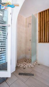 baño con ducha y puerta de cristal en Sandy Beach Hotel, en San Juan