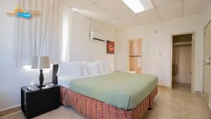 ein Hotelzimmer mit einem großen Bett und einem Fenster in der Unterkunft Sandy Beach Hotel in San Juan