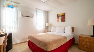 um quarto de hotel com uma cama grande num quarto em Sandy Beach Hotel em San Juan