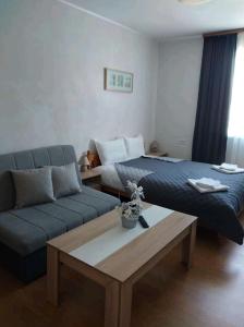 uma sala de estar com um sofá, uma cama e uma mesa de centro em Къща за гости КЕМО em Sapareva Banya