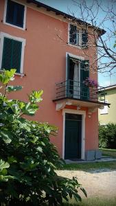 Casa de color naranja con balcón y puerta en B&B Il moro selvatico, en Poviglio