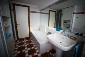 een witte badkamer met een wastafel en een spiegel bij Villa Forti in Castel Gandolfo