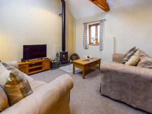 a living room with two couches and a flat screen tv at Combine Shed in Bidford