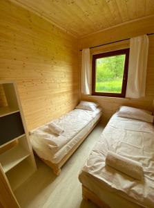 a room with two beds in a wooden cabin at Domki w Lipnicy in Lipnica