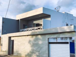 ein blaues Haus mit Garage in der Unterkunft Suítes Vovó Zilda in Maragogi