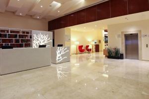 a lobby with a reception desk in a building at Hotel Opus Grand Toluca Aeropuerto in Toluca