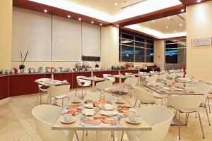 comedor con mesas y sillas y cocina en Hotel Opus Grand Toluca Aeropuerto en Toluca