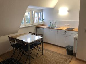 uma cozinha com uma mesa e cadeiras e um lavatório em Black Forest Bike Hostel em Kirchzarten