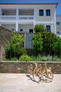 dos bicicletas estacionadas junto a una pared frente a un edificio en Krinos Suites Andros, en Ándros