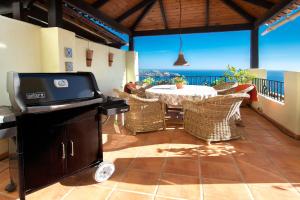 un patio con mesa, sillas y el océano en Casa 11 Vistas, en La Herradura