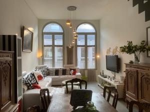 un soggiorno con divano e TV di WELLNESS LOFT with Sauna, Jacuzzi, Roof Terrace & Amazing View ad Anversa