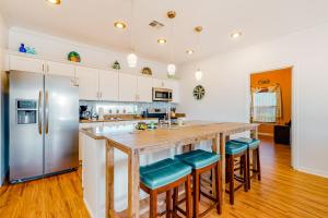 a kitchen with a large wooden island with blue seats at 4 Palms in Bolivar Peninsula