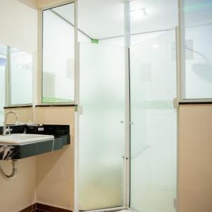 a glass shower in a bathroom with a sink at Prime Motel Campinas in Campinas