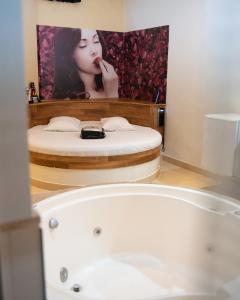 baño con bañera y una foto de una mujer en Prime Motel Campinas en Campinas