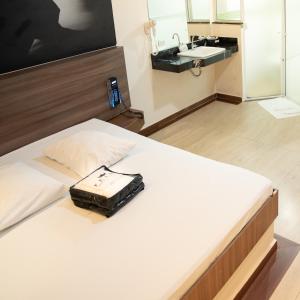 Una cama con una bolsa sentada en el baño en Prime Motel Campinas, en Campinas
