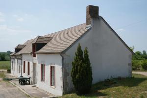 un petit bâtiment blanc avec un arbre en face dans l'établissement Gites de la Thiau, à Briare