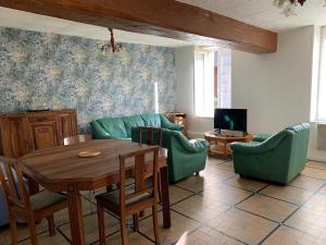 sala de estar con mesa, sillas y TV en Gites de la Thiau, en Briare