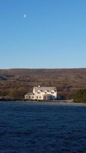 Turlough的住宿－Burren Rock Farmhouse B&B，坐在田野顶上的白色大房子