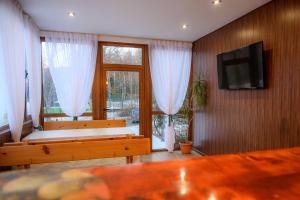 sala de estar con 2 bancos y TV de pantalla plana en Guest House Angelkovi en Sapareva Banya
