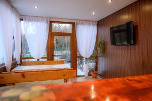 a living room with two benches and a flat screen tv at Guest House Angelkovi in Sapareva Banya