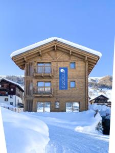 a log building with a sign on it in the snow at Moon Eco B&B in Livigno