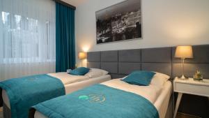 two beds in a hotel room with blue and white at Friends Hotel Bad Salzuflen in Bad Salzuflen +39 photos