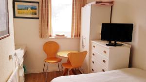 a bedroom with a bed and a tv and a chair at Castleton Hotel - Just for Adults in Paignton