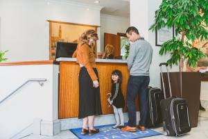 a woman and a man and a child standing at a counter at Hotel Rialto in Victoria