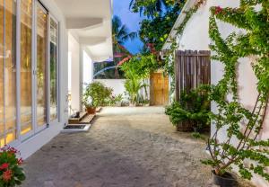 a courtyard of a house with a door and plants at Quicksand Rasdhoo in Rasdu