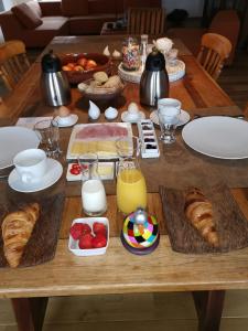 a wooden table with breakfast foods and drinks on it at Elingenhof in Elingen