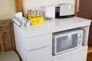 a white counter with a microwave on top of it at Maeda Forestry House - Vacation STAY 19184v in Furano