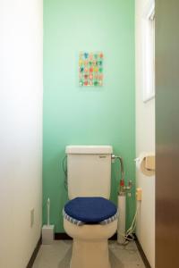 a bathroom with a white toilet with a blue seat at Maeda Forestry House - Vacation STAY 19585v in Furano