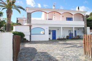 una casa con una palmera delante de ella en Es Caials, en Cadaqués