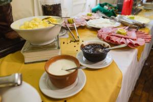 una mesa con dos tazas de café y platos de comida en MOVA - Hotel D'oeste, en Poços de Caldas