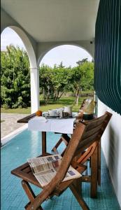a table and chairs on a patio with a view of a pool at Casa del Vigneto - NEW near VENICE - rooms+bathroom - INDEPENDENT in Spinea