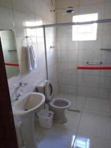 a bathroom with a toilet and a sink at Pousada Sol de Minas in Monte Sião