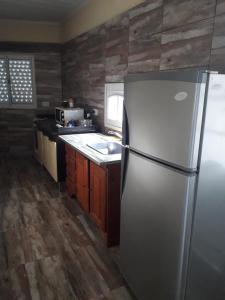 a kitchen with a stainless steel refrigerator and wooden floors at COMPLEJO DE DPTOS EN RAFAELA a pasitos de la RUTA 34 in Rafaela