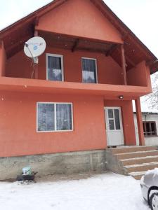 una casa en la nieve con un satélite en Casa Sandu, en Topliţa