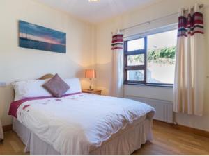 a bedroom with a bed and a window at Beachmount House in Ventry