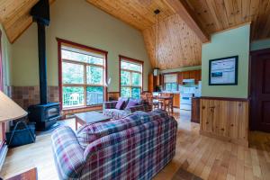een woonkamer met een bank en een fornuis bij Gîte du Mont-Albert - Sepaq in Sainte-Anne-des-Monts