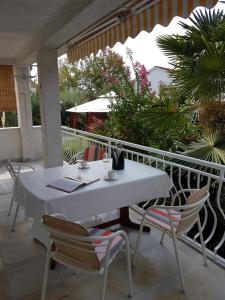 a white table and chairs on a balcony at Schreng Apartments in Malinska