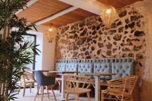 a room with tables and chairs and a stone wall at Apartamentos Cortijo Peñardera in Siles