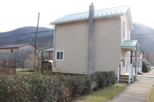 a small white building with a tin roof at Cool Vibes Cottage in Renovo